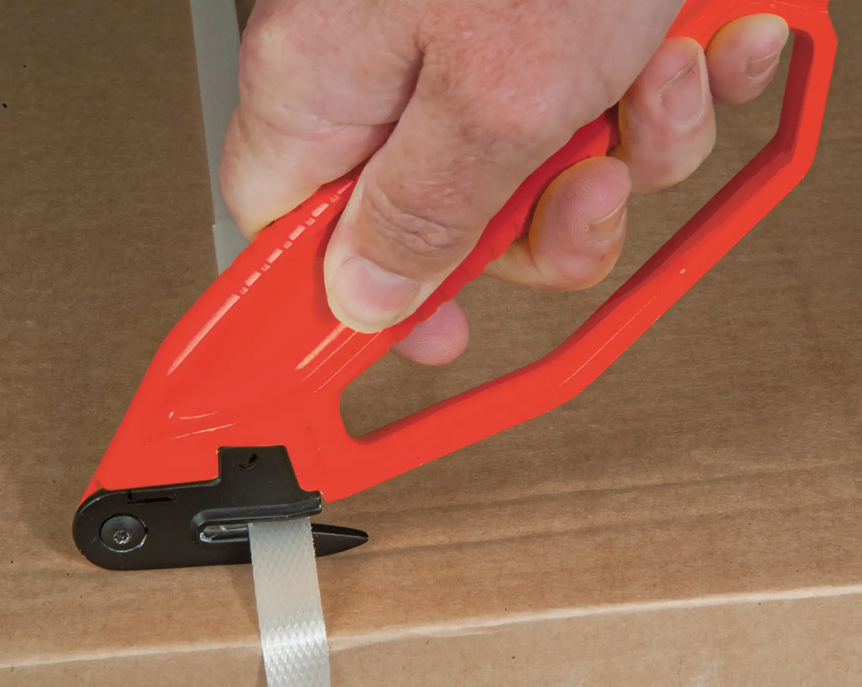STANLEY 0-10-245 strap cutter with red handle in use on packaging, close-up photo.