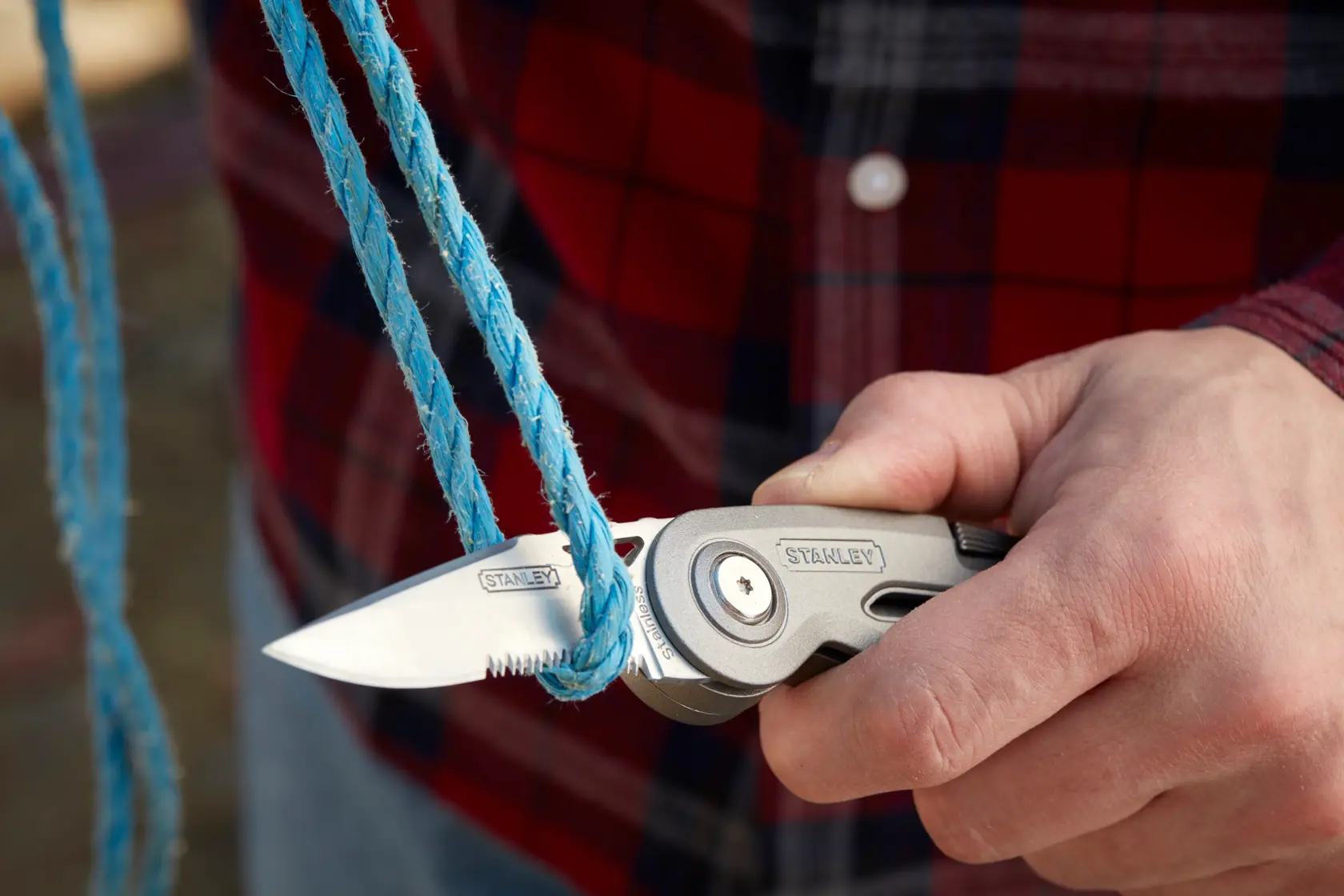 STANLEY 0-10-813 Klappmesser schneidet blaues Seil, Nahaufnahme.