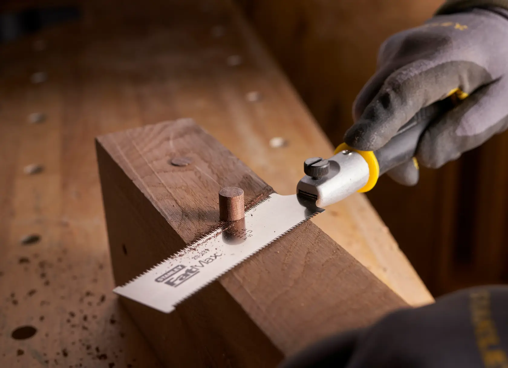 STANLEY 0-20-331 flush cut saw cutting wooden dowel on workbench, close-up angle.