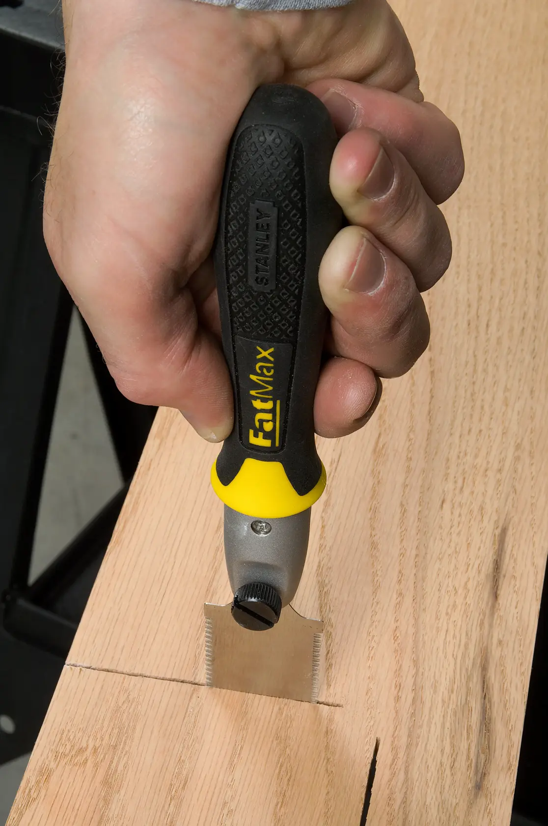STANLEY 0-20-331 FatMax saw with black and yellow handle cutting wood, close-up photography.