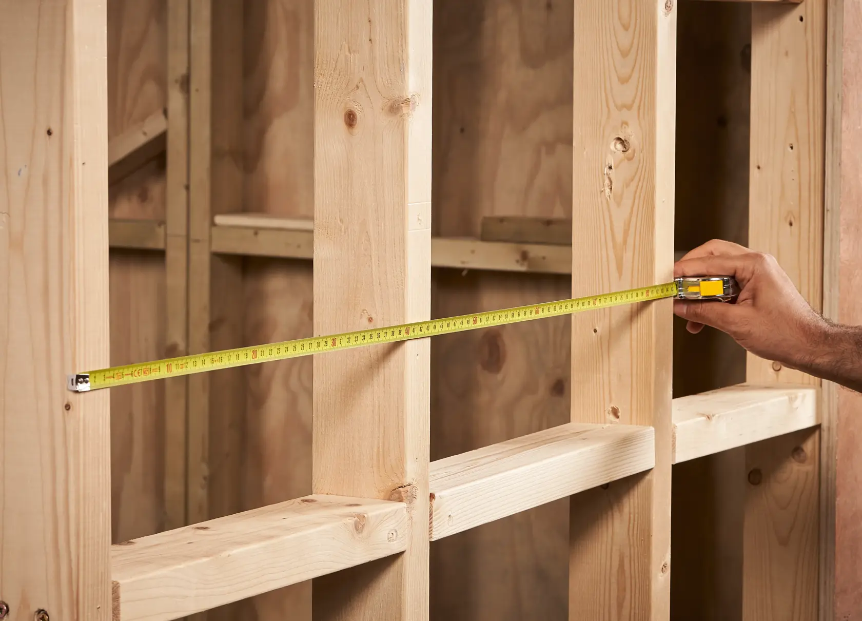 STANLEY 0-33-218 Maßband über Holzrahmen gespannt, Produktfoto in Anwendung.