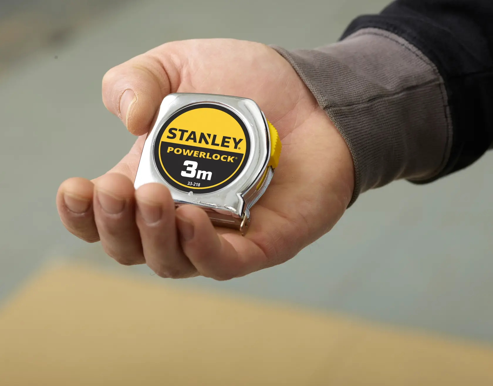 STANLEY 0-33-218 Bandmaß, 3m, kompaktes Chromgehäuse, in der Hand gehalten, Nahaufnahme.