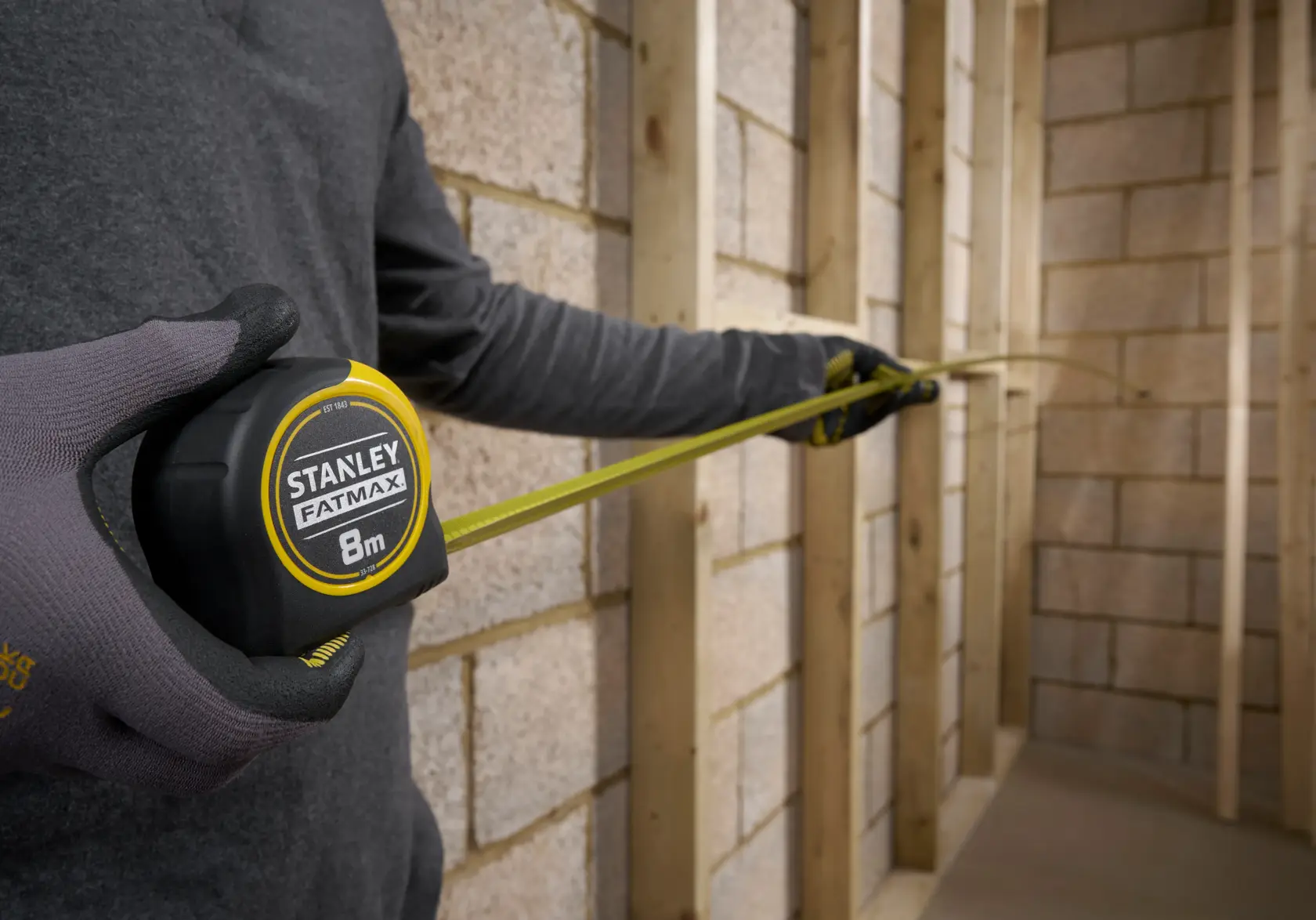 Stanley 0-33-728 tape measure with yellow blade measuring a window ledge, close-up photography.