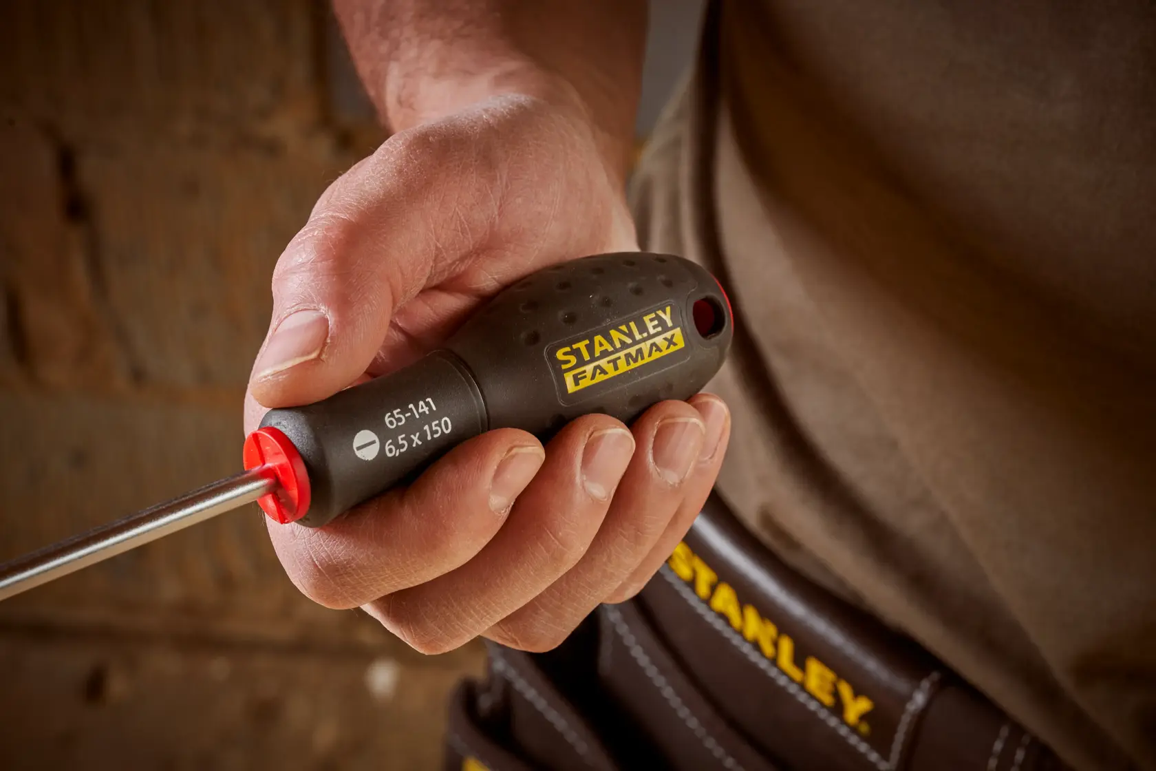 Photo of STANLEY 0-65-141 screwdriver with black and yellow handle, held in hand, close-up view.