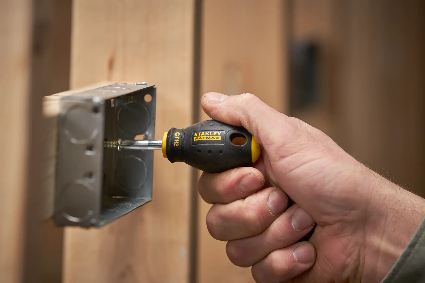 Photo of STANLEY 0-65-407 FATMAX screwdriver in use tightening metal box screw.