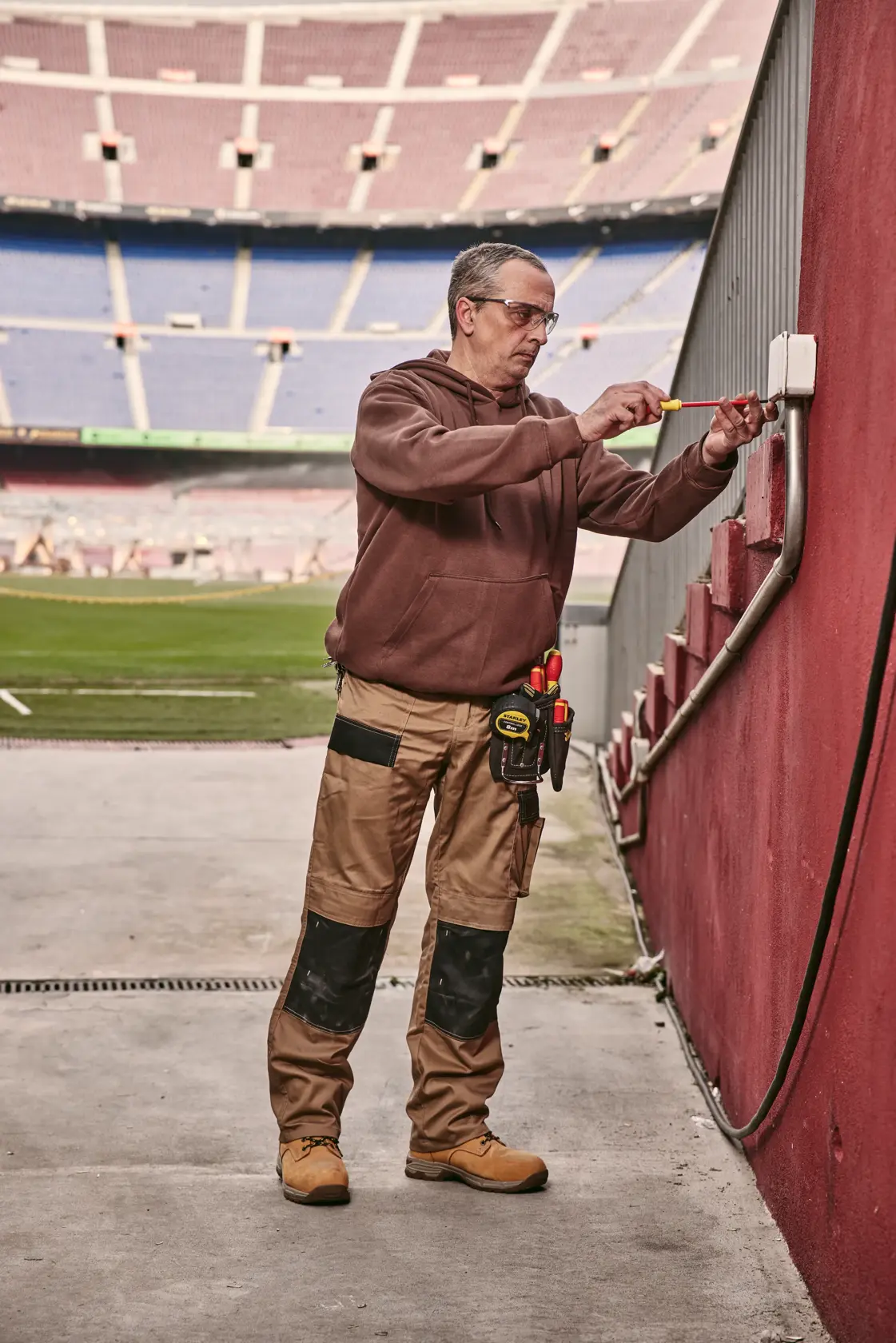 STANLEY 0-65-443 screwdriver used by a worker fixing an electrical box at a stadium.
