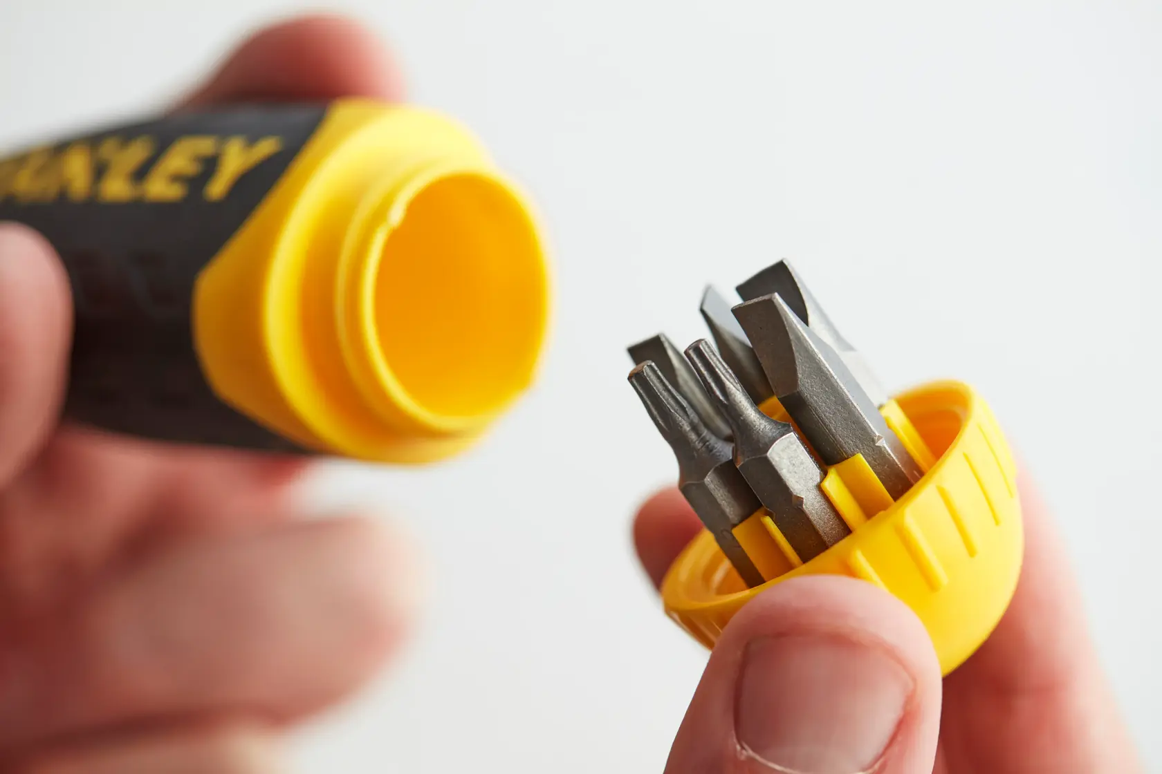 STANLEY 0-68-010 screwdriver handle with yellow cap holding assorted screwdriver bits, close-up.