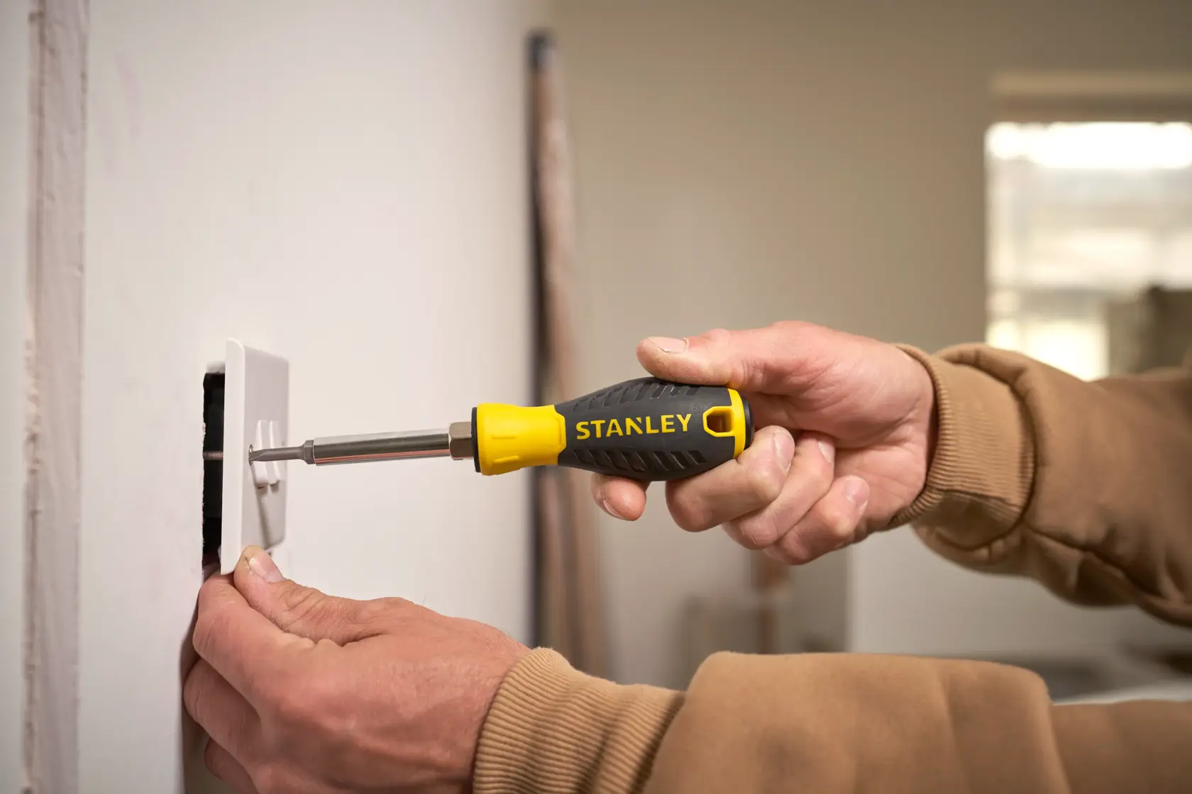 STANLEY 0-68-012 screwdriver with yellow and black handle used to install a wall socket.