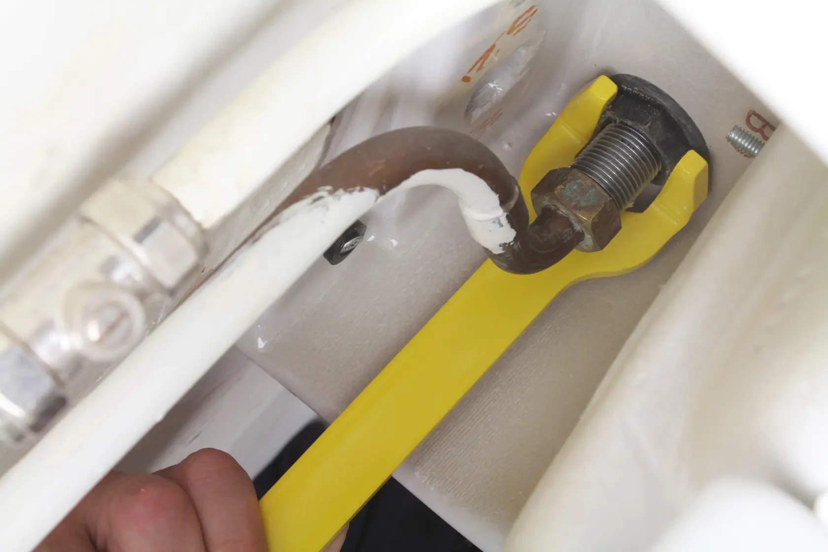 STANLEY 0-70-454 yellow pipe wrench tightening a pipe fitting, close-up photo.