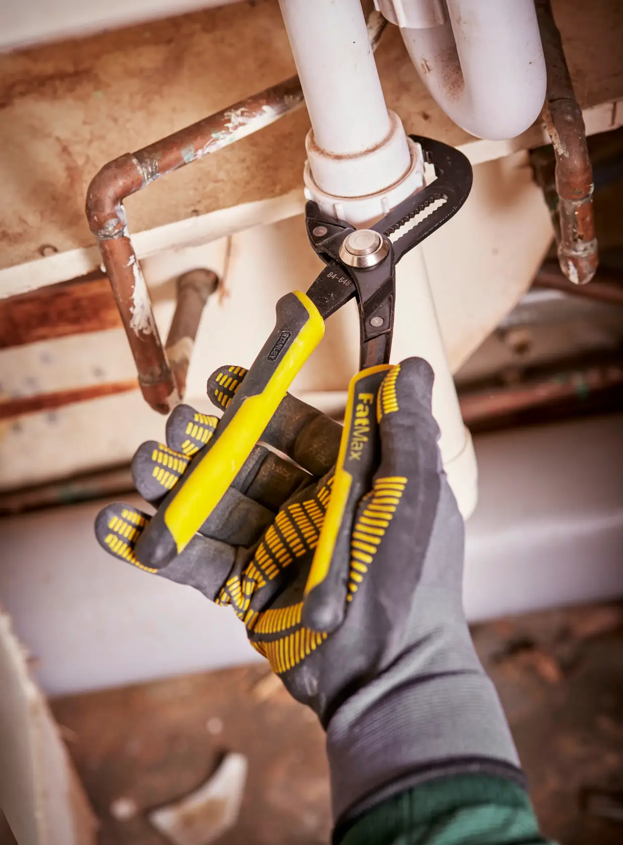Stanley adjustable pliers with black and yellow handles and serrated jaws, suitable for gripping or turning objects.