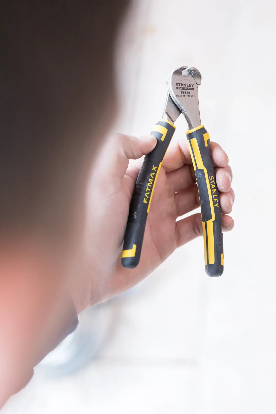 Photo of STANLEY 0-89-875 FATMAX end cutting pliers with black and yellow handles held in a hand.