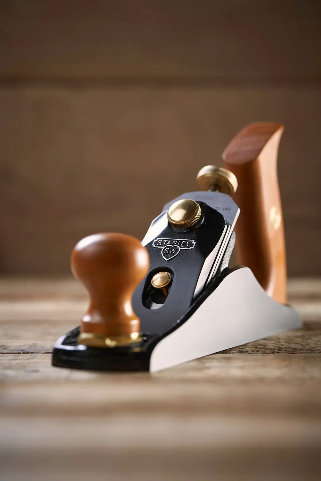 STANLEY 1-12-136 hand plane with wooden handles, angled view on rustic wood surface.