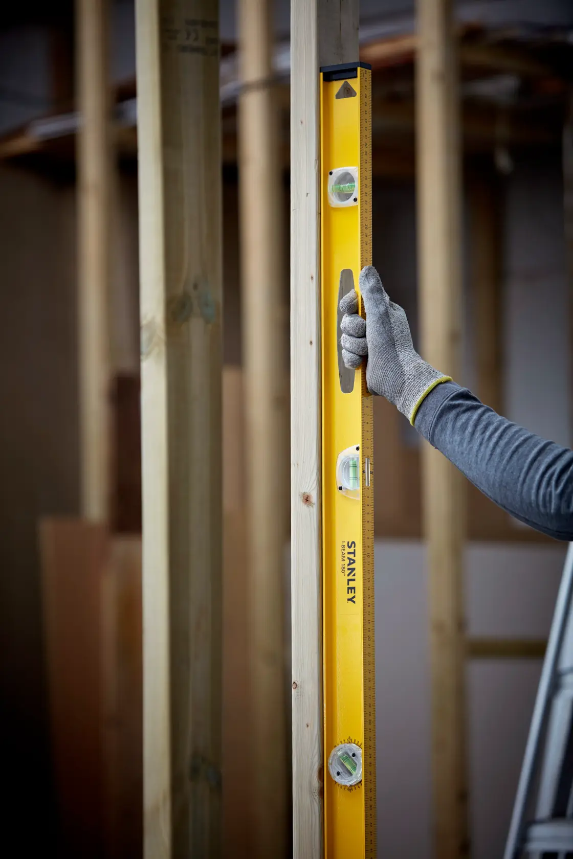 Photo of STANLEY 1-42-922 spirit level used vertically on wood frame construction.