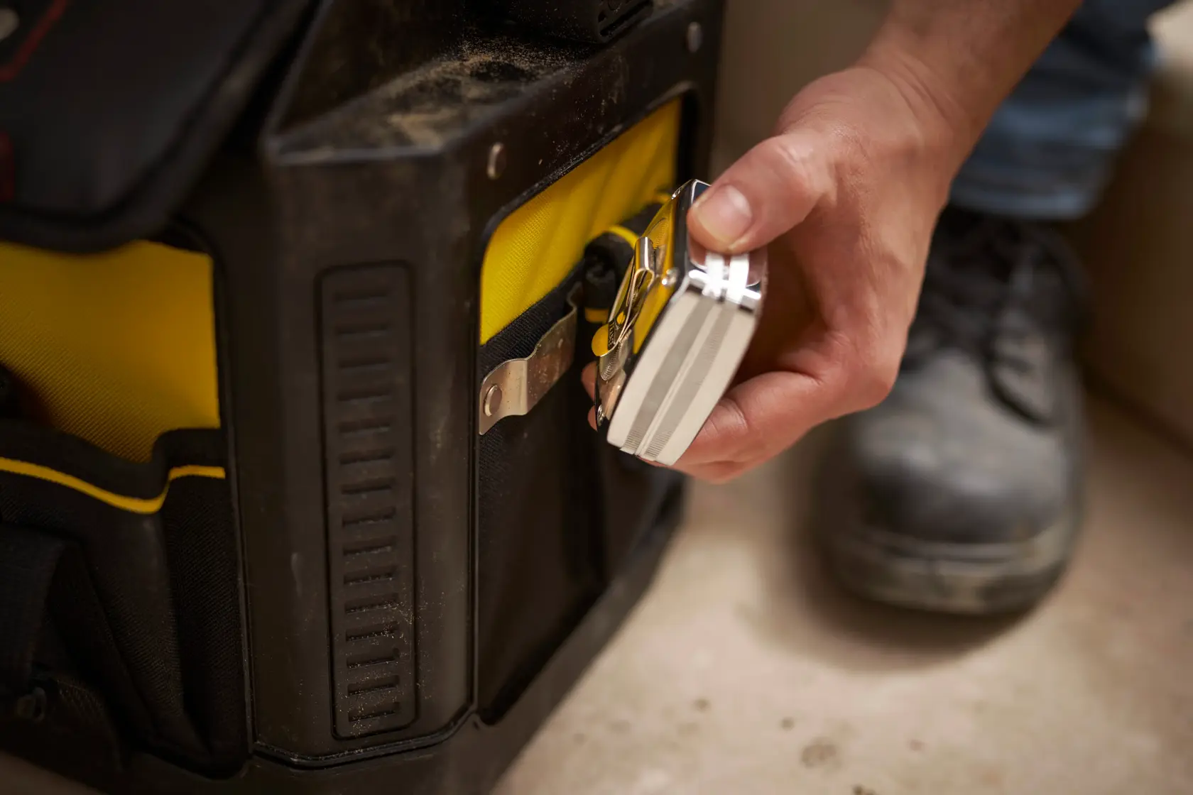 STANLEY 1-79-213 padlock attached to a yellow and black tool bag, close-up photography.