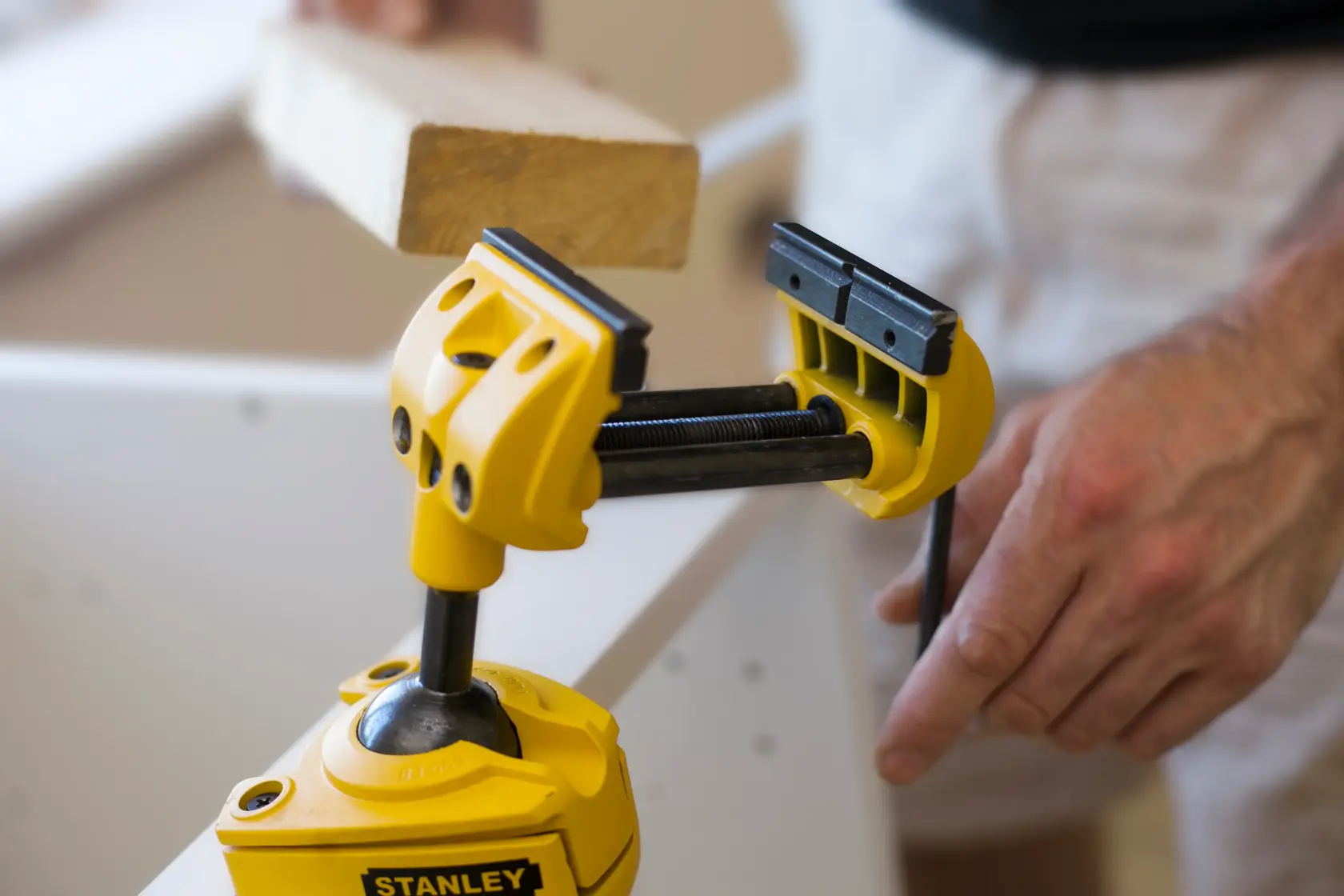 Stanley 1-83-069 gelbe verstellbare Schraubzwinge hält Holz, verwendet im Tischlerhandwerk, Nahaufnahme.