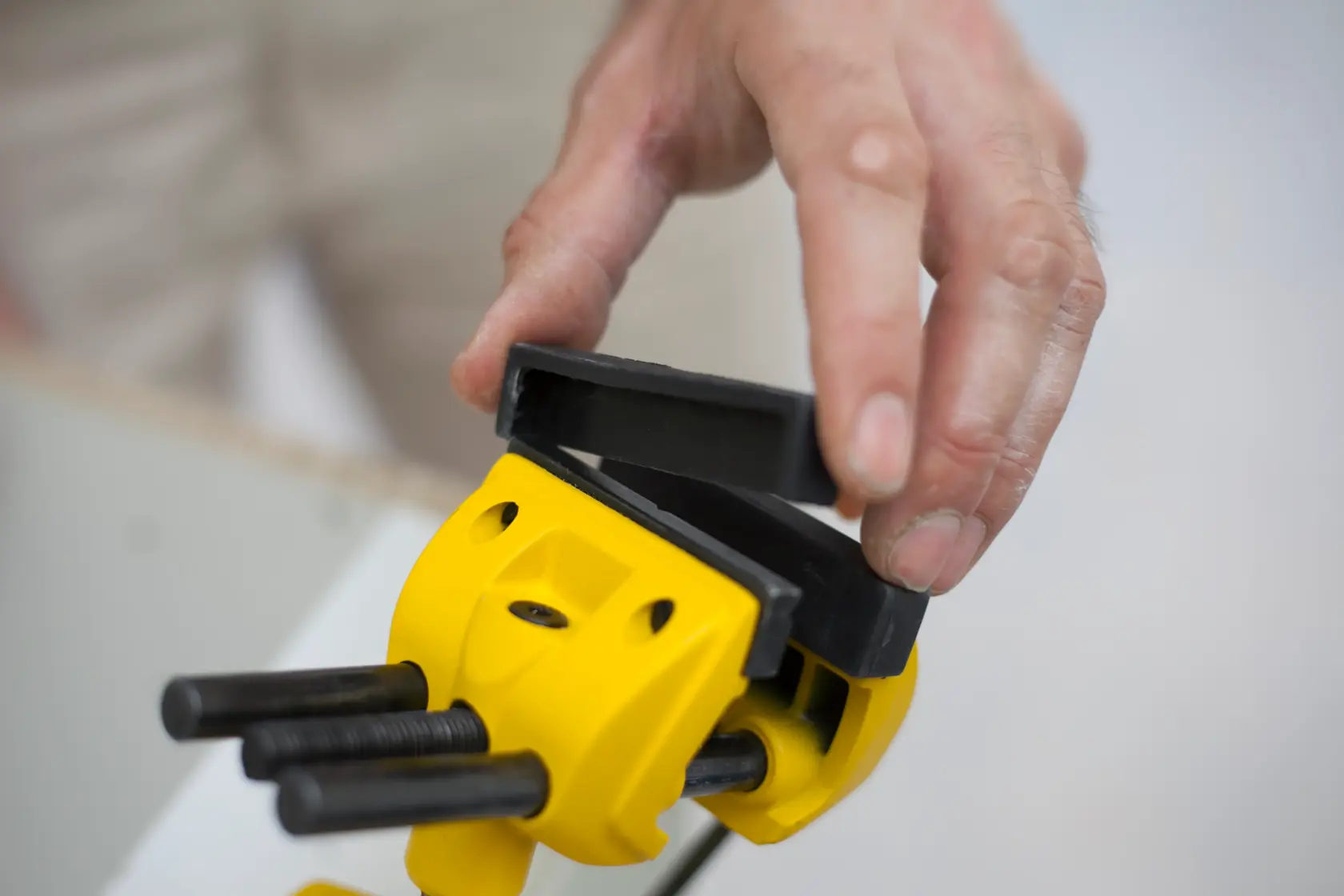 STANLEY 1-83-069 Fotografie einer gelben Klemme mit schwarzen Backen, die von Hand angepasst wird.
