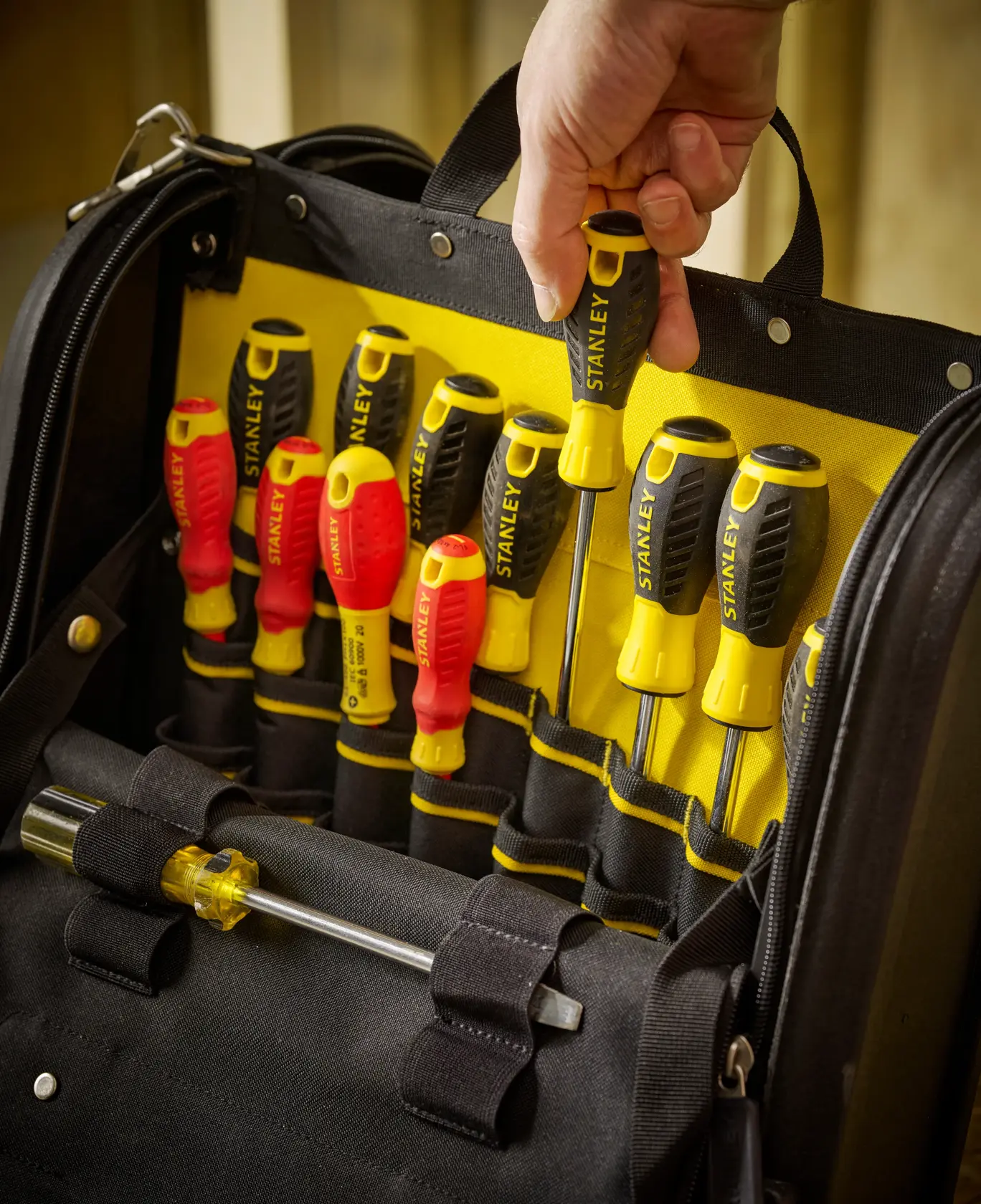STANLEY 1-94-231 screwdriver set in black and yellow tool bag, hand removing screwdriver, front angle.