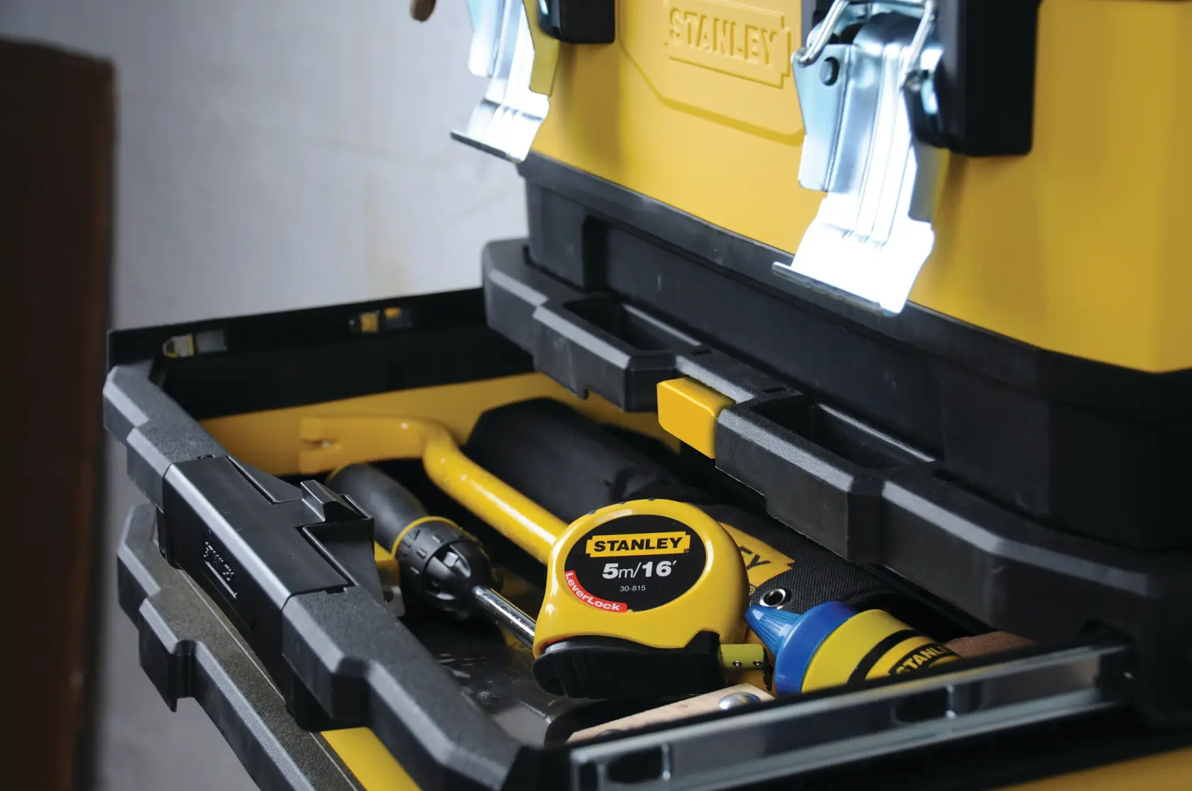 STANLEY 1-95-621 toolbox with open drawer showing tape measure and various tools inside, angled view.