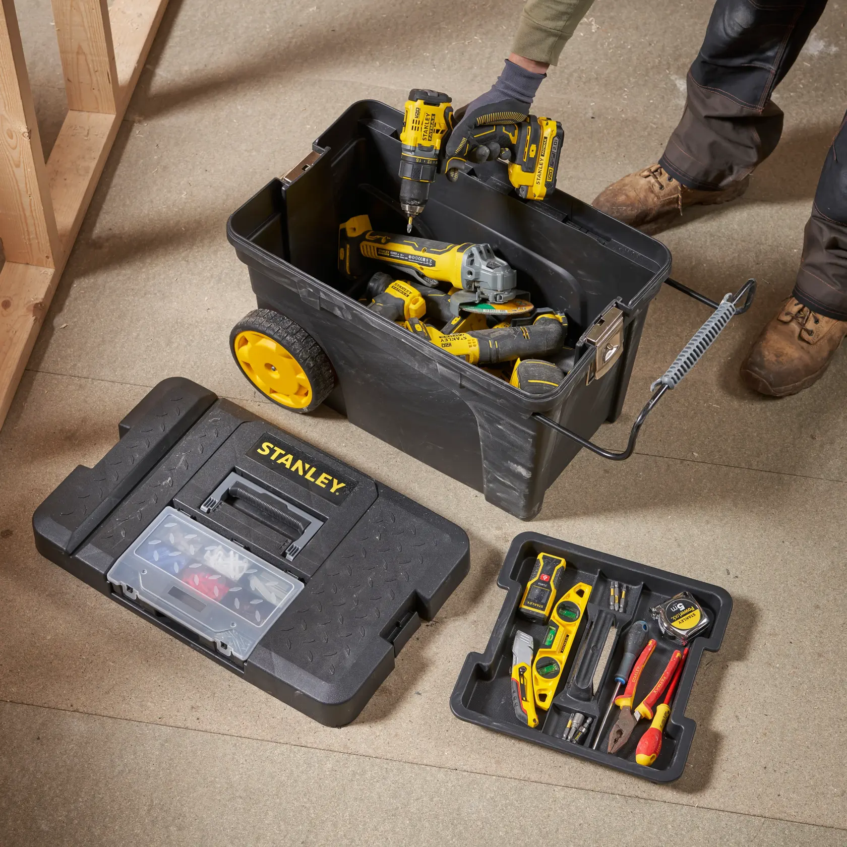 STANLEY 1-97-503 Werkzeugkasten-Fotografie mit gelben Rädern und verschiedenen Hand- und Elektrowerkzeugen im Inneren.