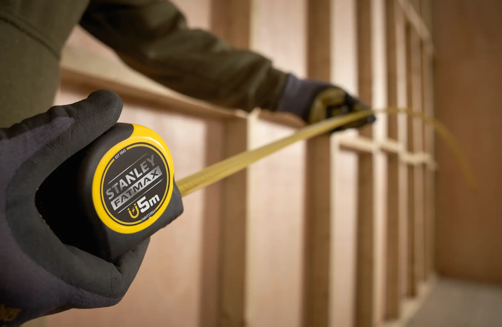 Photo of STANLEY FATMAX tape measure FMHT0-33864 being used to measure a wooden frame.