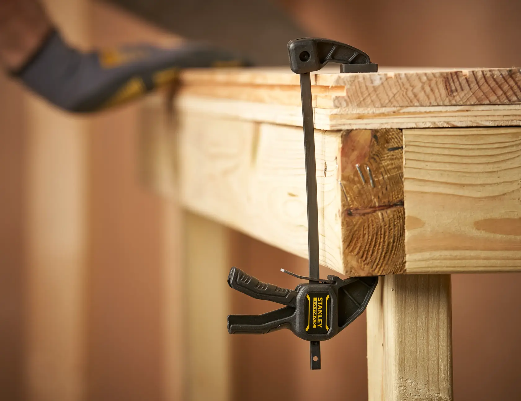 STANLEY FMHT0-83231 photography of bar clamp securing wooden workbench edge