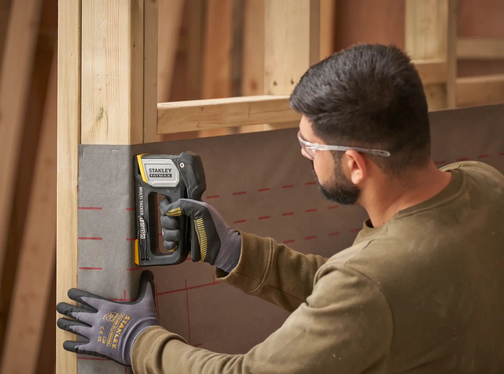 STANLEY FMHT70401-0 stapler used on construction site to fasten material to wooden frame.