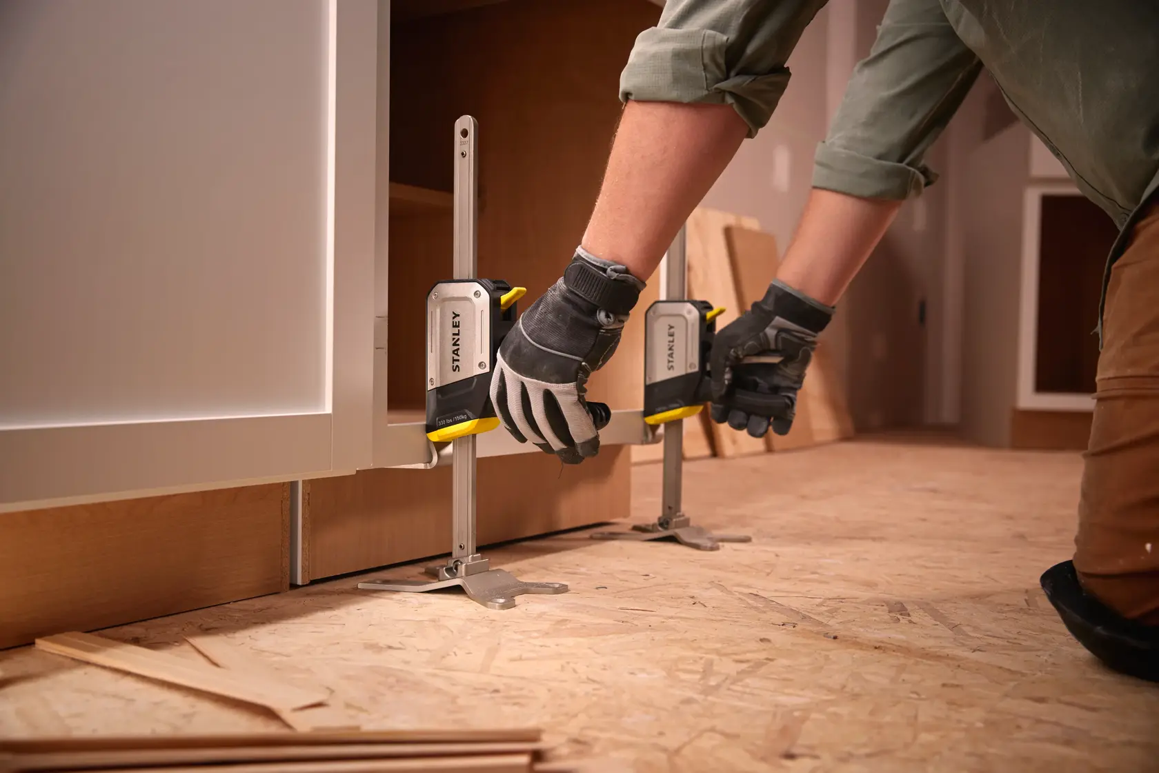 Stanley FMHT83550-1 Schrankklemme Fotografie, Arbeiter justiert Klemmen am Holzschrankboden.