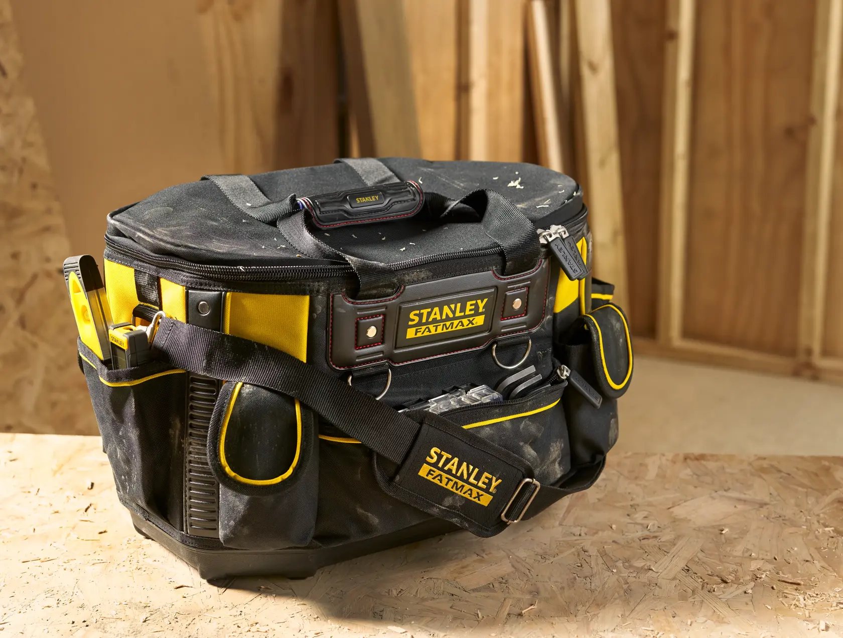 Stanley FMST1-70749 tool bag, black and yellow fabric, FatMax logo, sturdy base, shoulder strap, in workshop.