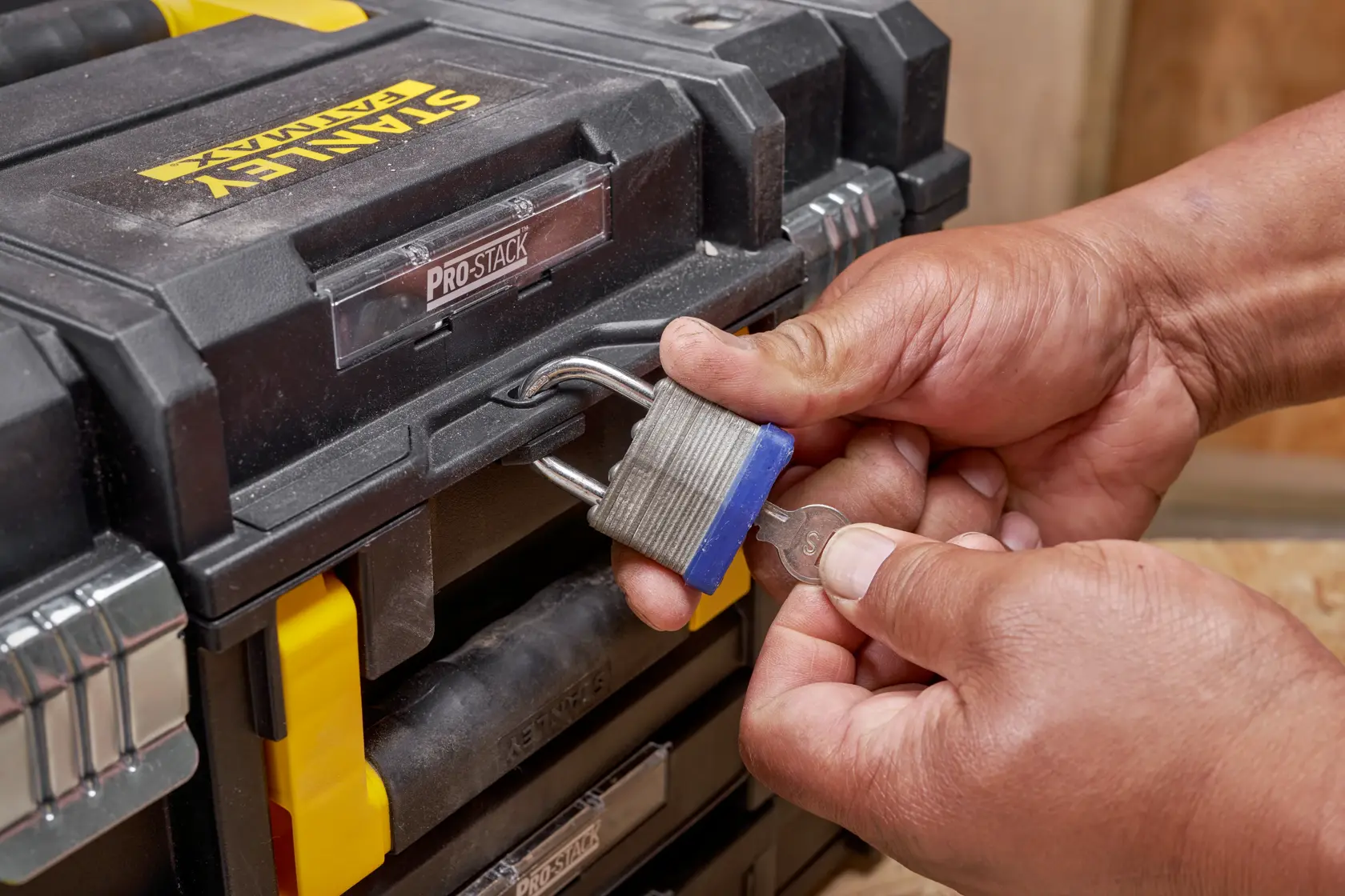 STANLEY FMST1-71981 toolbox close-up with hands unlocking padlock, showing front details.