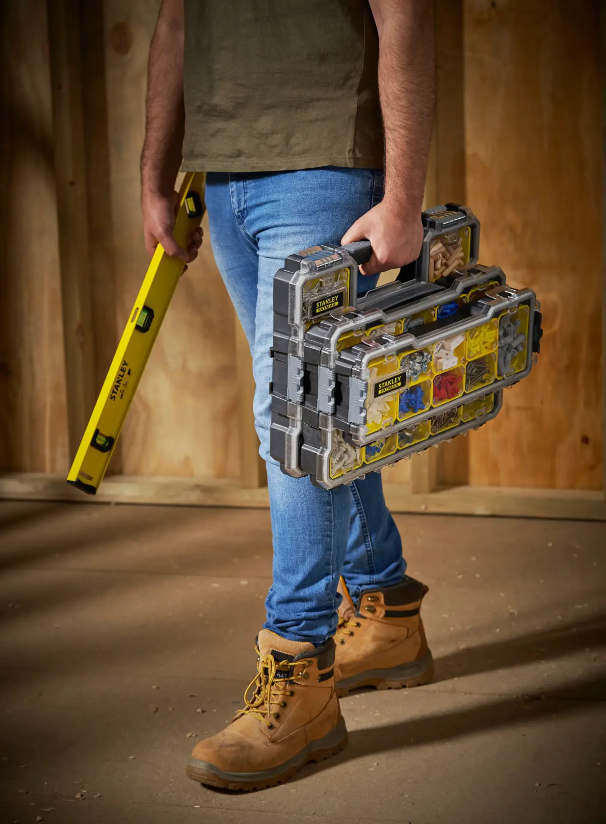 Photo of STANLEY FMST1-75781 organizer carried by person, filled with hardware, indoors on worksite.