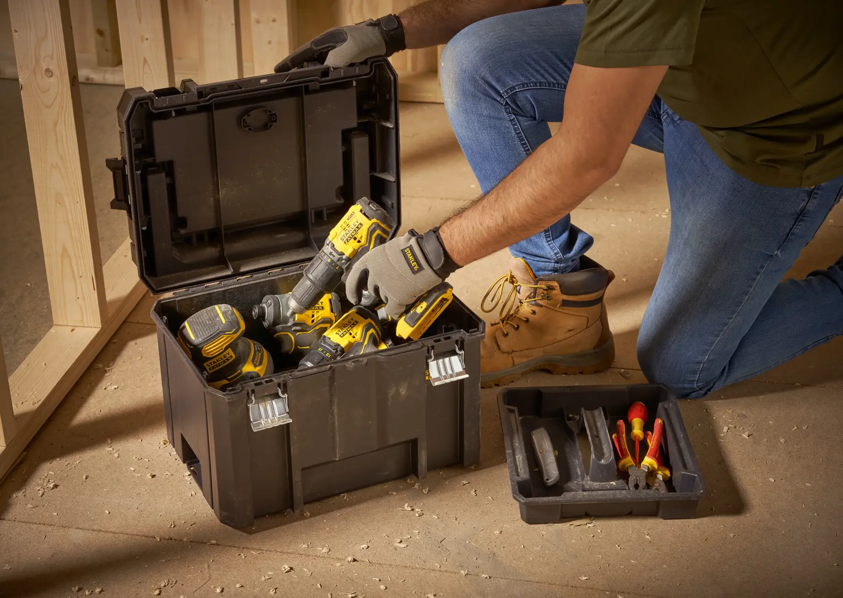 STANLEY FMST1-75796 tool box, open, filled with power tools and hand tools, indoor workshop setting.