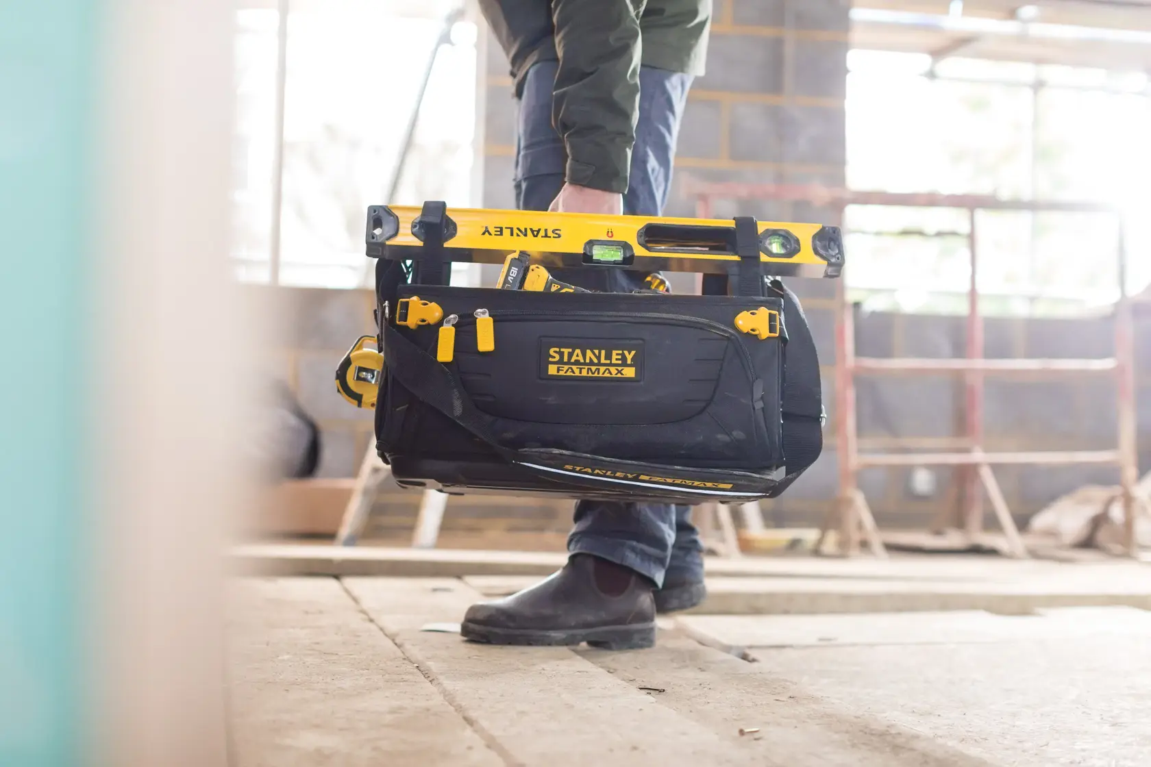 Photo of STANLEY FMST1-80146 FATMAX tool bag with yellow tools on a construction site.