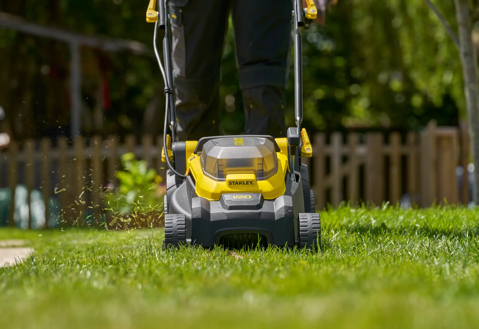 Foto des STANLEY SCMWP3401M1-XE Akku-Rasenmähers auf Gras, Vorderansicht mit gelb-schwarzem Design.