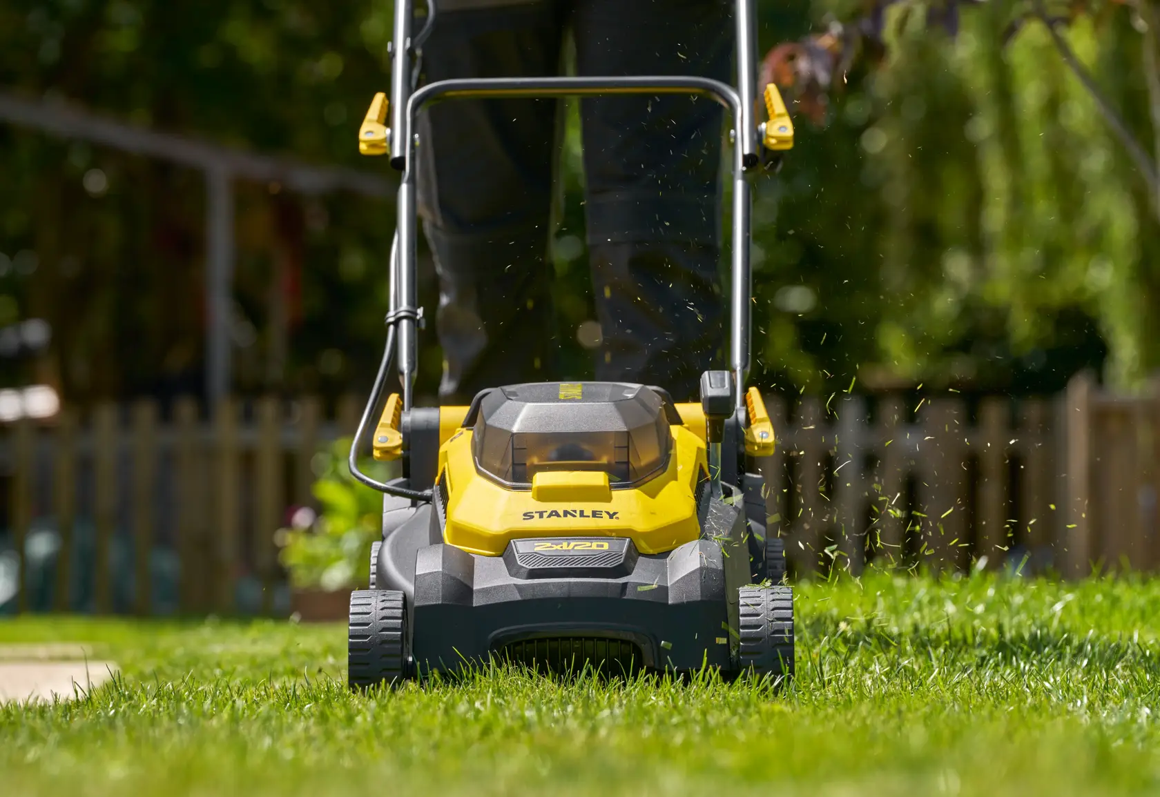 STANLEY SCMWP3701M2 kabelloser Rasenmäher Vorderansicht beim Rasenschneiden im Freien.