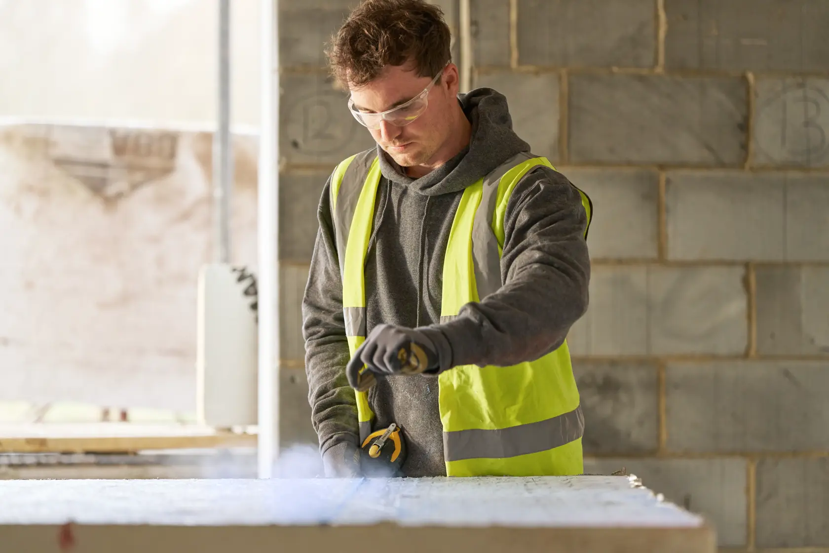 Photo of STANLEY STHT47311-0 construction worker using a tool on a jobsite, wearing a high-visibility vest.