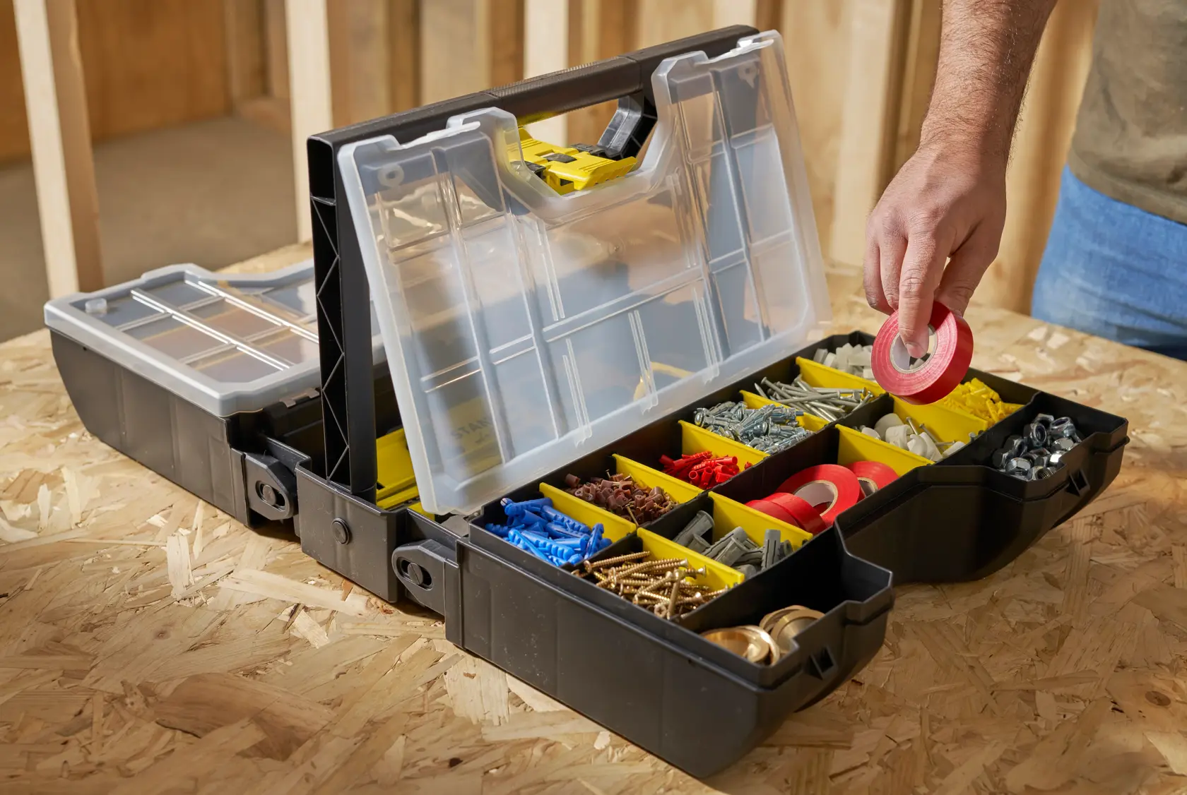 STANLEY STST1-71963 organizer box with clear lid and yellow compartments, photo of hand picking red tape.
