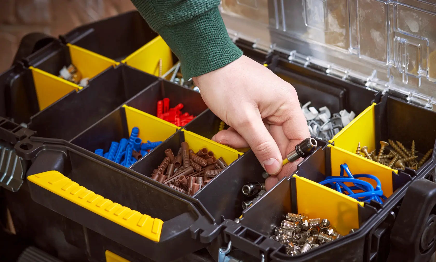 STANLEY STST1-79231 Organizer-Box mit gelben Trennwänden, verschiedene Befestigungen, Nahaufnahme mit Hand.
