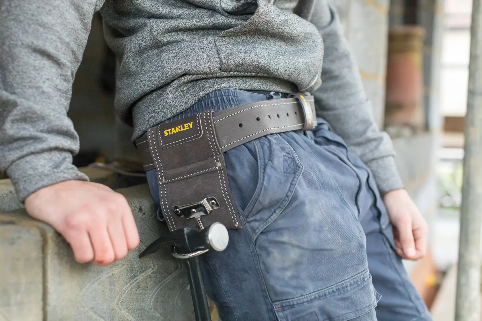 STANLEY STST1-80117 Leder-Hammerhalter am Gürtel befestigt, Outdoor-Arbeitsumgebung, Produktfotografie.